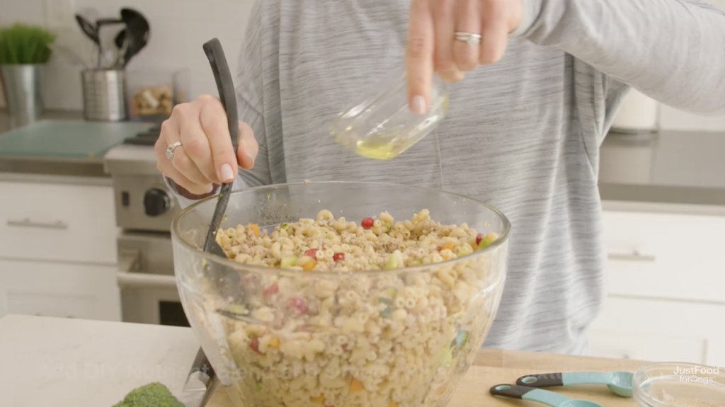 woman adding omega oil to dog food